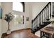 Bright foyer features wood flooring, a staircase with dark wood banister, and a glass front door at 5255 Apache Moon, Carmel, IN 46033