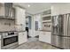 Renovated kitchen with stainless steel fridge and stove, and herring bone tile floor at 5255 Apache Moon, Carmel, IN 46033