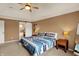 Comfortable bedroom with a ceiling fan, soft carpet, side tables, a barn door, and a window view at 5255 Apache Moon, Carmel, IN 46033