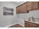 Stylish laundry room features wooden cabinets, granite counters, and artistic wall decor at 5291 Nettleton Way, Avon, IN 46123
