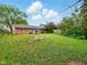 Large backyard with grass, trees, and a brick house at 5305 N Cork Dr, Muncie, IN 47304