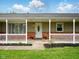 Charming front porch with a white picket fence and an oval-glass front door at 5305 N Cork Dr, Muncie, IN 47304
