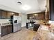 Bright kitchen with stainless steel refrigerator, dark cabinets, and neutral countertops at 5305 N Cork Dr, Muncie, IN 47304