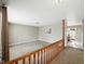 Open-concept living room with neutral carpet, paint, and wood railing at 5305 N Cork Dr, Muncie, IN 47304