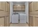Well-lit laundry room with wood cabinets above a white washer and dryer at 5499 Steven Dr, Greenwood, IN 46142