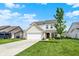 Beautiful two-story home with an attached garage, a lush green lawn, and mature trees in a serene setting at 5518 Wood Spring Ln, McCordsville, IN 46055