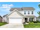 Charming two-story home featuring a two-car garage, a manicured lawn, and a welcoming front entrance at 5518 Wood Spring Ln, McCordsville, IN 46055