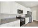 Modern kitchen with white cabinets, stainless steel appliances, and granite countertops at 5518 Wood Spring Ln, McCordsville, IN 46055