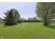 Lush backyard showcasing a sprawling green lawn and mature trees at 5646 Skipping Stone Dr, Indianapolis, IN 46237