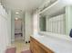 Well-lit bathroom with a large mirror, white counter, and shower with a decorative curtain at 5646 Skipping Stone Dr, Indianapolis, IN 46237