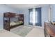 Bedroom featuring a wooden bunk bed, gray rug, light blue walls, and a window with blue curtains at 5646 Skipping Stone Dr, Indianapolis, IN 46237