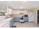 Kitchen features a tile floor, updated appliances, and updated blue and white cabinets at 5646 Skipping Stone Dr, Indianapolis, IN 46237