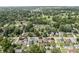 An aerial view shows a quiet neighborhood with tree-lined streets and a golf course in the distance at 6051 Lowell Ave, Indianapolis, IN 46219