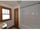 Bright bathroom featuring a shower and tub combination, wooden framed window, and a single sink vanity at 6051 Lowell Ave, Indianapolis, IN 46219