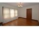Dining area featuring hardwood floors and a large window with sheer curtains at 6051 Lowell Ave, Indianapolis, IN 46219