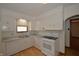 Bright kitchen features white cabinets, stainless sink, gas range and wood flooring at 6051 Lowell Ave, Indianapolis, IN 46219