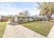 Inviting one-story house showcases a long driveway, and a well-manicured lawn with mature trees at 617 Grovewood Dr, Beech Grove, IN 46107