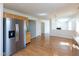 Bright kitchen opening to a dining area with a modern refrigerator and hardwood flooring at 6516 Amherst Way, Zionsville, IN 46077