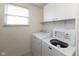 Functional laundry room features a side-by-side washer and dryer and overhead cabinets for storage at 6516 Amherst Way, Zionsville, IN 46077