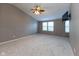 Large main bedroom with vaulted ceiling, ceiling fan, wall-mounted TV, and windows providing natural light at 6516 Amherst Way, Zionsville, IN 46077