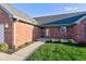 Close-up of a brick home's front entrance with a storm door, landscaping, and walkway at 710 Monarch Ln, Lebanon, IN 46052
