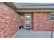 Close-up of a brick home's front entrance with a welcome mat and storm door at 710 Monarch Ln, Lebanon, IN 46052