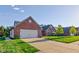 Charming brick home featuring an attached two-car garage and a well-manicured lawn at 710 Monarch Ln, Lebanon, IN 46052