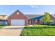 Charming brick home featuring an attached two-car garage and a well-manicured lawn at 710 Monarch Ln, Lebanon, IN 46052