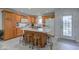 Kitchen features a central island with breakfast bar, wooden cabinets, white appliances, and gray tile floors at 710 Monarch Ln, Lebanon, IN 46052