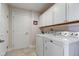 Functional laundry room with white washer and dryer, plus ample storage at 710 Monarch Ln, Lebanon, IN 46052