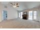 Carpeted living room featuring a fireplace, ceiling fan and access to the backyard through a set of patio doors at 710 Monarch Ln, Lebanon, IN 46052