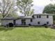 Expansive backyard featuring a spacious deck, lush green lawn, and mature trees at 7216 N Parker Ave, Indianapolis, IN 46240