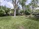 Lush backyard with mature trees, a play set, and a fire pit area for outdoor enjoyment at 7216 N Parker Ave, Indianapolis, IN 46240