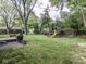 Spacious backyard featuring a play set, mature trees, and a well-maintained lawn, perfect for Gathering fun at 7216 N Parker Ave, Indianapolis, IN 46240