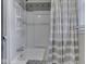 This bathroom features a bathtub with a shower, patterned tiles, and a gray and white striped shower curtain at 7216 N Parker Ave, Indianapolis, IN 46240