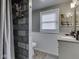 Cozy bathroom showcasing stylish grey tile in shower, beadboard, modern fixtures, and natural light at 7216 N Parker Ave, Indianapolis, IN 46240