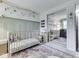 Delightful Bedroom featuring a crib, wall art, and light color palette creating a serene and playful environment at 7216 N Parker Ave, Indianapolis, IN 46240