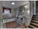 Charming bedroom with window seat, red rug, large clock, and decorative staircase to the side at 7216 N Parker Ave, Indianapolis, IN 46240