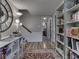 Hallway with wooden floors and a large clock, leading to a bedroom and staircase at 7216 N Parker Ave, Indianapolis, IN 46240