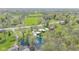 Expansive aerial view of a neighborhood with lush greenery, a serene pond, and well-spaced homes at 7310 W 100 N, Greenfield, IN 46140