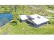 Stunning aerial view of modern home with large deck and beautiful pond surrounded by lush green lawn at 7310 W 100 N, Greenfield, IN 46140