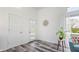 Bright foyer featuring modern doors, wood-look floors, a statement clock, and an inviting plant at 7310 W 100 N, Greenfield, IN 46140