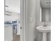 Pedestal sink in a well-lit, neutral-toned powder room with a glimpse into the dining and kitchen space at 7645 Marin Pkwy, Cumberland, IN 46229