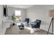 Living room featuring plush chairs, a glass coffee table, and a large bright window at 7645 Marin Pkwy, Cumberland, IN 46229