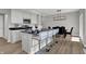 Modern kitchen with white cabinets, stainless steel appliances, and an island with breakfast bar at 7651 Marin Pkwy, Cumberland, IN 46229