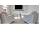 Cozy sitting area with two armchairs, a small table, and a wall-mounted TV for comfortable relaxation at 7651 Marin Pkwy, Cumberland, IN 46229