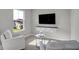 Comfortable sitting area with armchairs and wall mounted TV offers a relaxing view from the picture window at 7651 Marin Pkwy, Cumberland, IN 46229