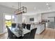 Open concept dining area with a modern light fixture and an island with bar seating nearby at 7663 Marin Pkwy, Cumberland, IN 46229