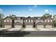 A view of the townhomes with brick facade, individual garages, and well-maintained landscaping at 7663 Marin Pkwy, Cumberland, IN 46229