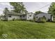 Spacious backyard showcasing the home's exterior, lawn, and detached garage at 7702 Mary Ln, Indianapolis, IN 46217